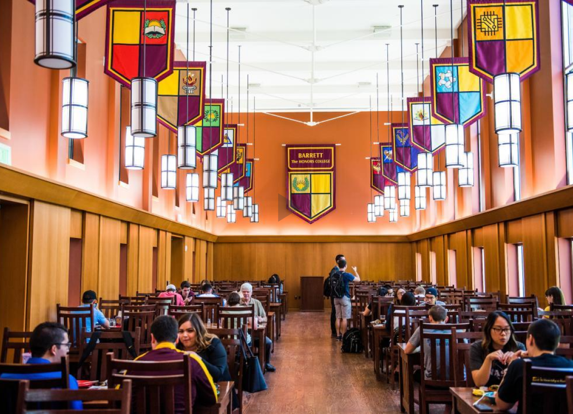 A spacious room showcasing many people gathered around tables