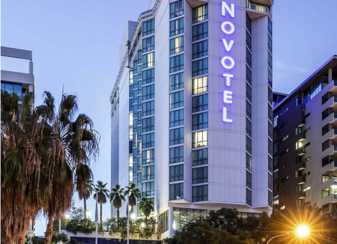 Exterior view of a hotel featuring a clear sign that states "Novotel," highlighting its contemporary design and inviting atmosphere